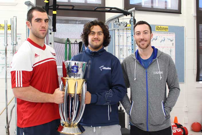 graduate and students with super rugby trophy